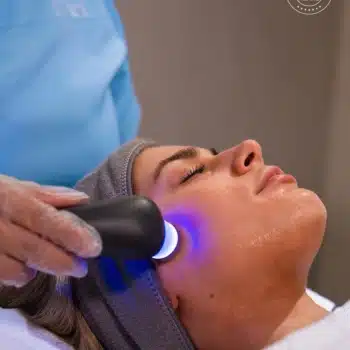 Woman receiving a Dermoregen facial treatment with a skincare device
