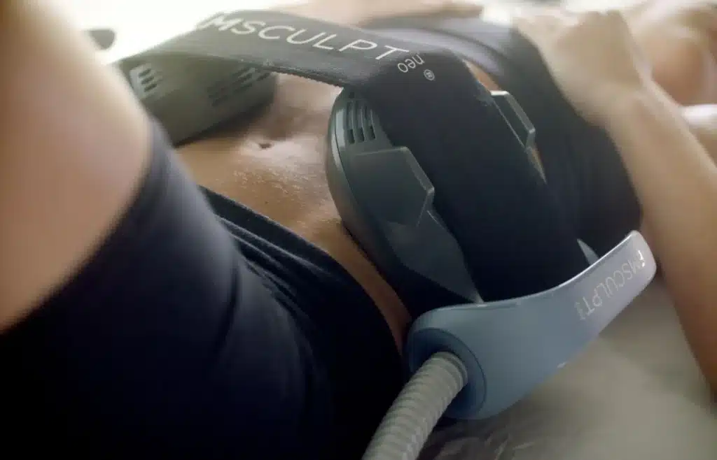 EMSCULPT NEO applicator positioned on the abdomen during a non-surgical body contouring treatment